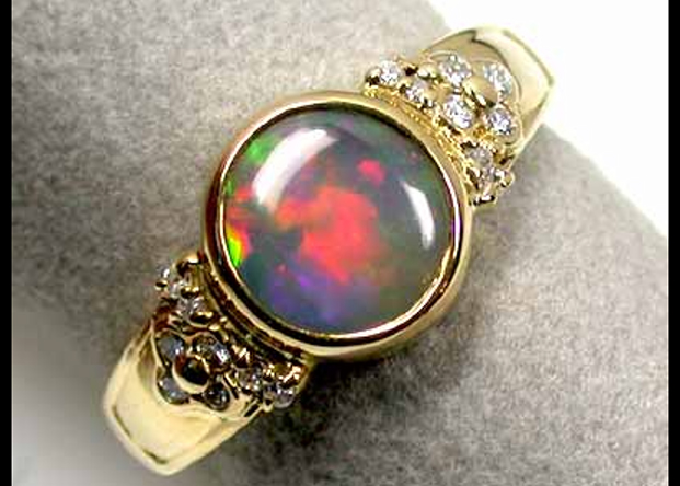 Graphic of an a circle cut fire opal set in yellow gold with a diamond surround.